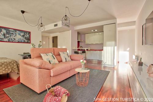 穆尔西亚Walker Apartamento Centro Murcia con parking privado的一间带粉色沙发的客厅和一间厨房