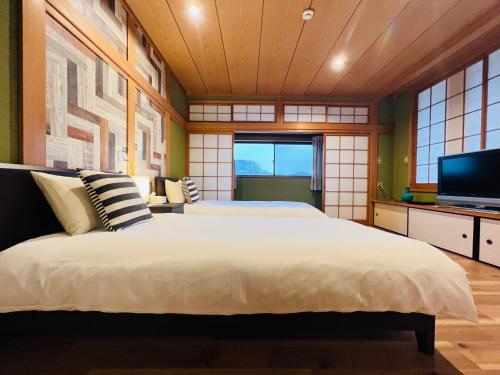 奈良NARA日本庭院别墅的一间卧室配有一张大床和电视