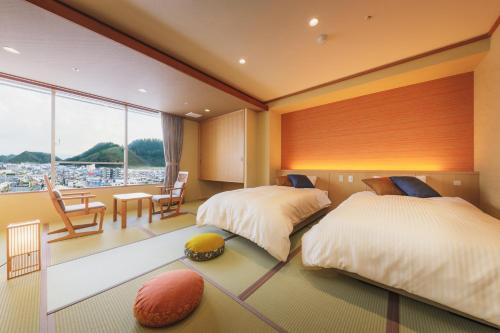 天童市天童酒店的一间卧室配有两张床和一张桌子及椅子