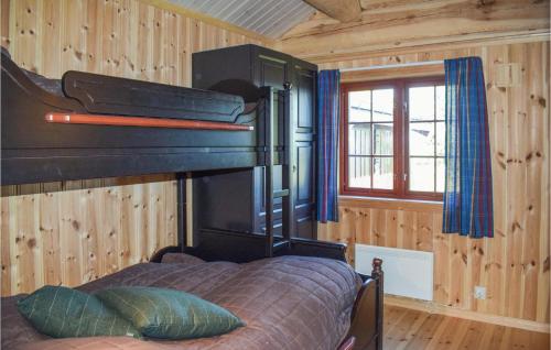 内斯比恩Awesome Home In Nesbyen With Kitchen的木制客房内的一间卧室,配有一张床