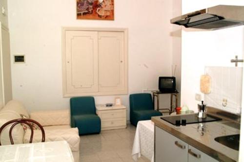 索伦托Villa Orchidea的厨房以及带2把椅子和1张沙发的起居室。
