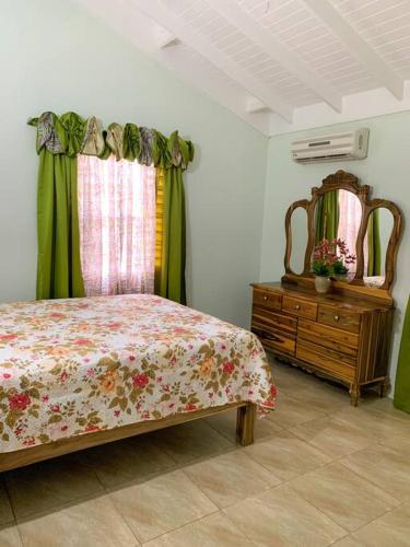 曼米湾Cozy Villa的一间卧室配有一张床、梳妆台和镜子