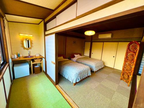 京丹后市Japanese style hotel Morigen的小房间设有两张床和镜子