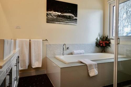 Bream CreekWaterfront 'Jemadda' Family Lodge的白色的浴室设有浴缸和窗户。