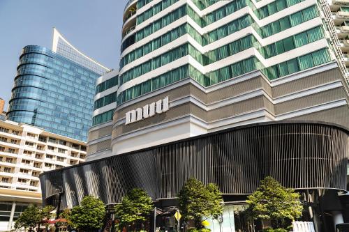曼谷曼谷MUU酒店的一座高大的建筑,旁边有一个标志