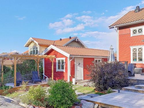 Rindö8 person holiday home in VAXHOLM的前面有长凳的红色房子