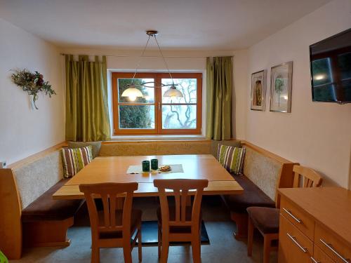 瓦格赖恩Haus Hinterfürbach的一间带木桌和椅子的用餐室
