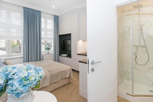 索波特La Boutique Studio Sopot的一间卧室设有一张床和一个玻璃淋浴间
