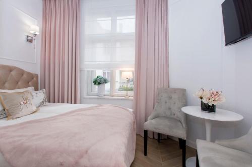 索波特La Boutique Studio Sopot的一间卧室配有一张床、一张桌子和一个窗户。
