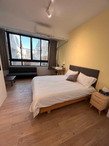 Hu-nei茄萣黄金海岸民宿的一间卧室设有一张大床和一个大窗户