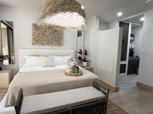 维雷亚Tiki Tiki - Gorgeous Boho Beach Hideaway!的一间卧室配有一张大床和一个大型吊灯。