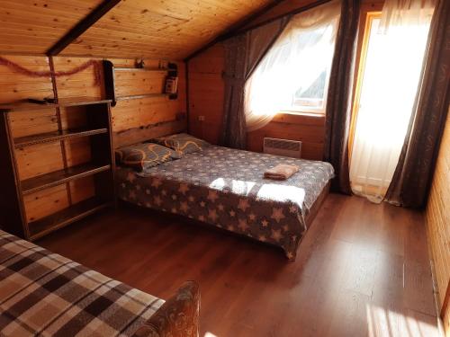沃罗赫塔Котедж Віадук的小屋内的卧室,配有床和2扇窗户