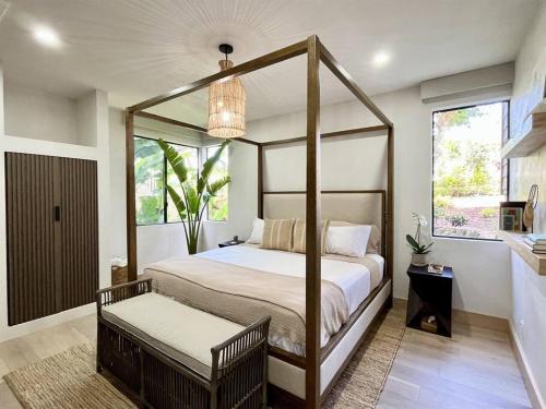 维雷亚Aloha Moon - A Chic and Dreamy Modern Tropical Hideaway!的一间卧室设有天蓬床和窗户。