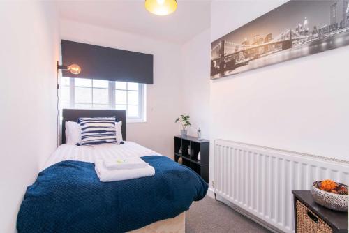 达宁顿堡Stylish & Central 2 bedroom apartment - Fast WiFi的一间卧室配有一张带蓝色毯子的床