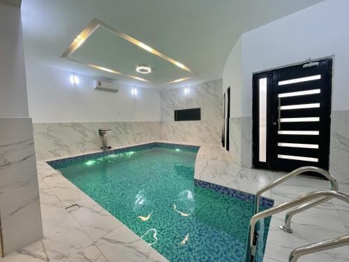 Al Rakaشاليه الروح AlRooh Chalet的一间位于客房内的带游泳池的浴室