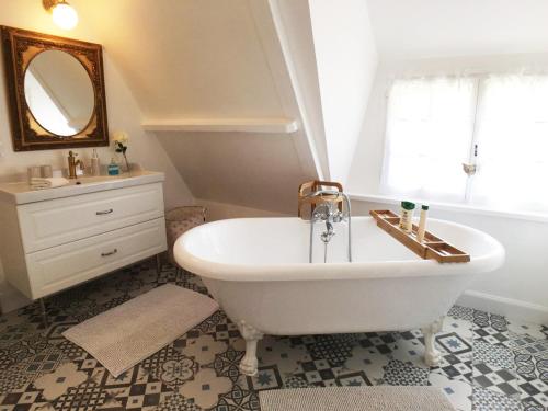 Berville-sur-MerLa Romance et la Romanesque的带浴缸、水槽和镜子的浴室