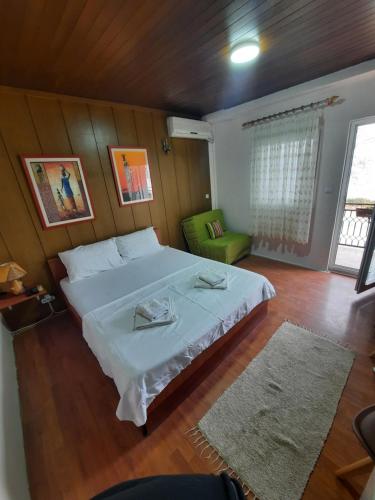 诺弗多伊兰Apartmani Teodora的一间卧室配有一张大床和一张绿色椅子