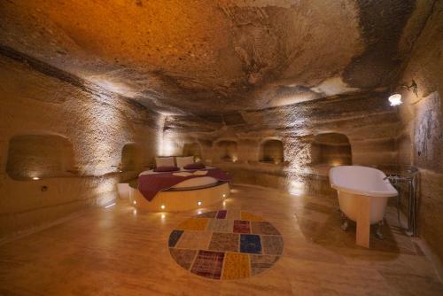 格雷梅Göreme Cave Lodge的洞穴内带床和浴缸的房间