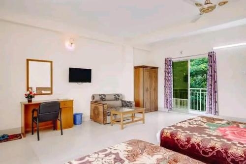 BāndarbanHill Crown Hotel & Resort的一间卧室配有一张床、一张书桌和一台电视