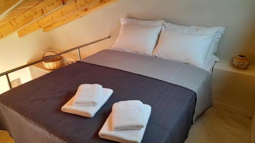 TavariLesvos Tavari bay的一间卧室配有一张床,上面有两条毛巾