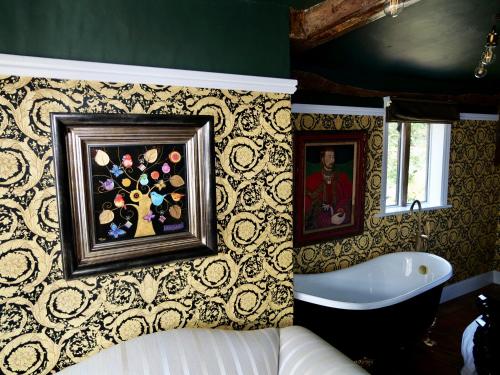 萨弗伦沃尔登Captivating 9-Bed House Hot Tub Near Cambridge的带浴缸的浴室和墙上的绘画