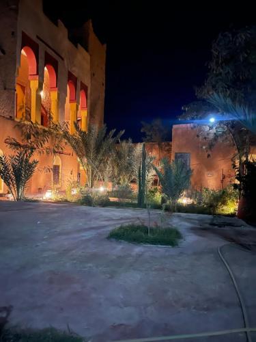 TissintRyad lcaid的一座带庭院的建筑,晚上有灯光
