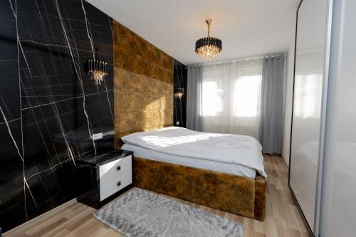 普里什蒂纳Dodona ApartHotel in Prishtina的一间卧室设有一张床和瓷砖墙