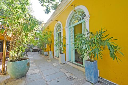 蓬蒂切里Hotel Villa Des Gouverneurs的前面有盆栽植物的黄色建筑