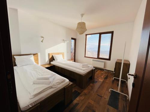 DobărskoFarmhopping Village的客房设有两张床和窗户。