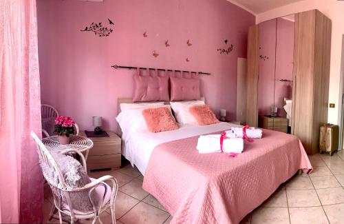 维拉普特祖Butterfly House的粉红色的卧室配有一张大床和两把椅子