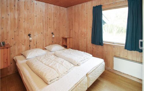Kolby KåsBeautiful Home In Sams With Kitchen的卧室配有一张木墙内的大床