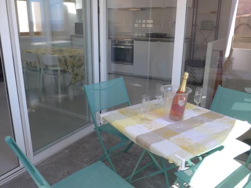 博尼法乔Duplex sur un fameux Grain de sable的一张桌子、一瓶葡萄酒和两把椅子