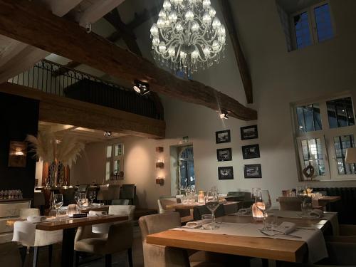 MachelenDon Jon的一间带桌椅和吊灯的用餐室
