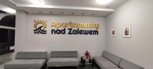 斯诺科Apartament Nad Zalewem Zegrzyńskim的一间配有沙发的等候室和墙上的标志