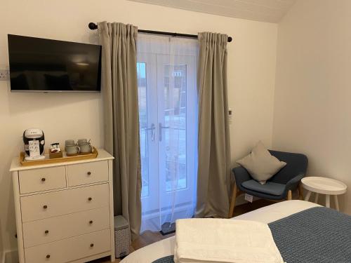 普里茅斯Rural Retreat in Devon的一间卧室配有一张床、一个梳妆台和一扇窗户。