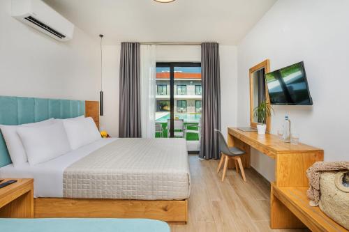 斯卡拉福卡斯AlexMare Hotel Fourka的配有一张床、一张书桌和一扇窗户的酒店客房