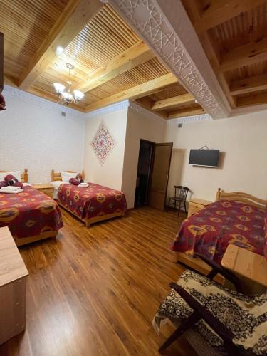 布哈拉Mutara Bukhara的客房设有两张床和一台平面电视。