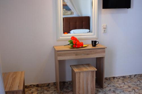 卡马利甜心一室公寓酒店的一张桌子,上面有镜子和一碗鲜花
