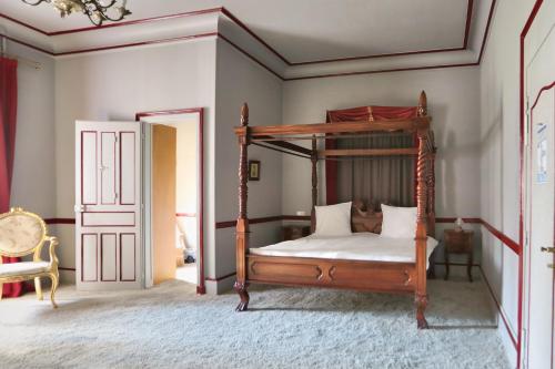 Lurcy-LévisChâteau de Béguin的卧室配有带白色床单的天蓬床