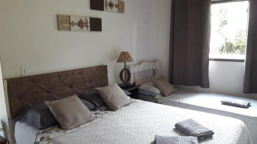 索科罗Chalé das Alamandas的一间卧室设有两张床和窗户。