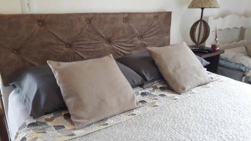 索科罗Chalé das Alamandas的一张带两个枕头和棕色床头板的床
