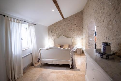 瓦朗索尔Gite Le Figuier - La Roseraie du Val'ensoleillé的卧室配有白色的床和窗户。