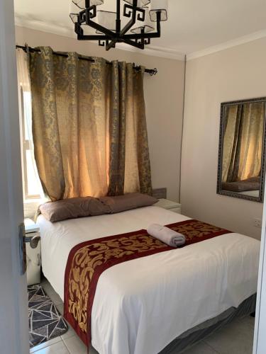 哈博罗内Sekaka Fully Furnished Apartments的一间卧室配有一张带吊灯的床。