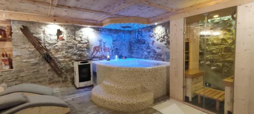 拉瓦罗内Haus Green & Spa Angelika Trentino的一间石墙内带浴缸的浴室