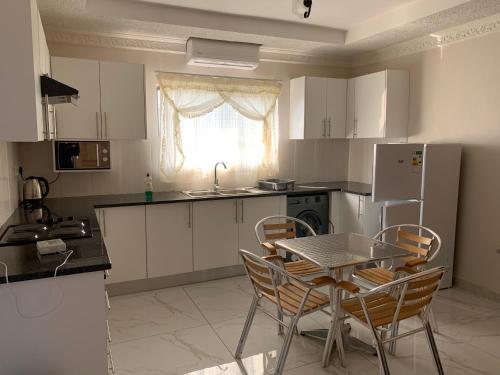 哈博罗内Sekaka Fully Furnished Apartments的厨房配有桌椅和冰箱。