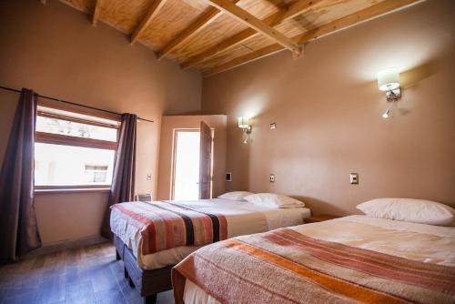 圣佩德罗·德·阿塔卡马拉科切拉酒店 的酒店客房设有两张床和窗户。