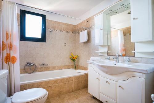 拉扎克利翁Villa Natasha的一间带水槽、浴缸和卫生间的浴室