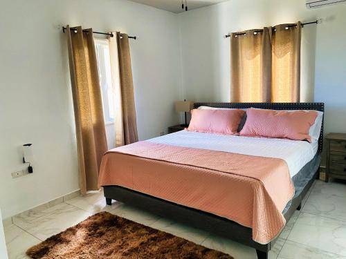 Oyster PondSea-Renity的卧室配有一张带粉红色枕头的大床