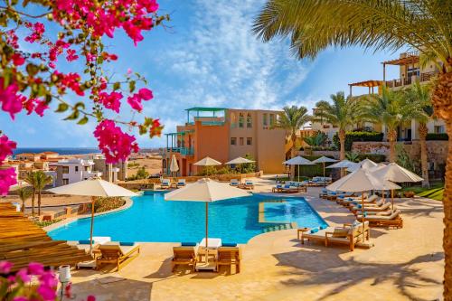 赫尔格达Zen Resort Sahl Hasheesh by TBH Hotels的一个带椅子和遮阳伞的游泳池的度假酒店