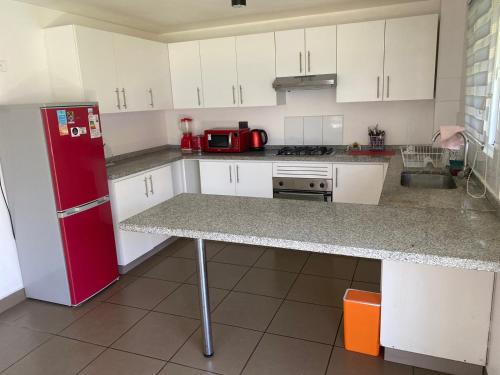 圣地亚哥Casa 3 habitaciones exclusiva valle lo campino的厨房配有红色冰箱和白色橱柜